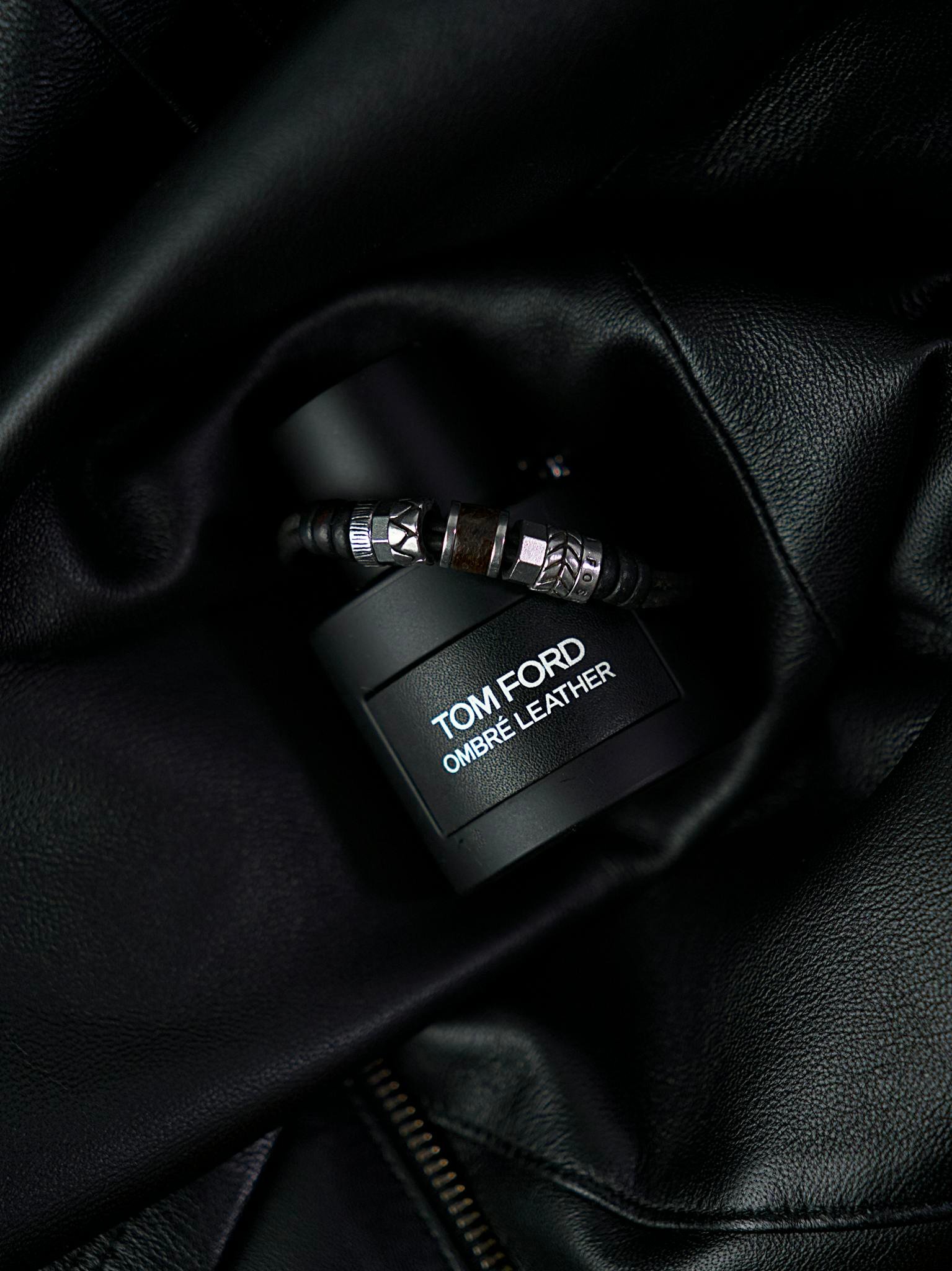 Luxury Tom Ford Ombré Leather fragrance bottle styled on dark leather backdrop.